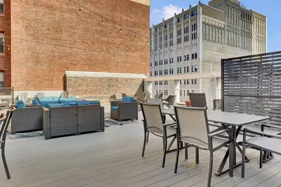 a patio with tables and chairs on a building at Luxury lofts, Downtown, Playhouse Sq, Near Stadium and Arena, Fire Pit, Rooftop deck, BBQ, Parking -fcfs, Close to EVERYTHIHNG! in Cleveland