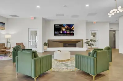 a living room with two green chairs and a tv at Luxury lofts, Downtown, Playhouse Sq, Near Stadium and Arena, Fire Pit, Rooftop deck, BBQ, Parking -fcfs, Close to EVERYTHIHNG! in Cleveland