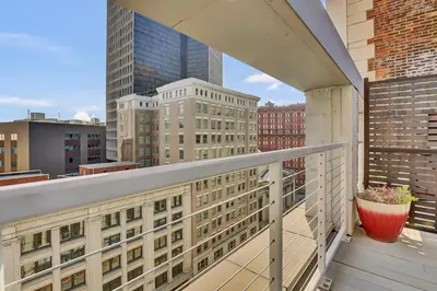 a balcony with a view of a city with tall buildings at Luxury lofts, Downtown, Playhouse Sq, Near Stadium and Arena, Fire Pit, Rooftop deck, BBQ, Parking -fcfs, Close to EVERYTHIHNG! in Cleveland