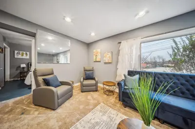 a living room with a couch and chairs and a window at Blue Bayou Cozy in South Cleveland in Cleveland