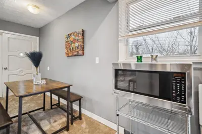 a kitchen with a table and a microwave at Blue Bayou Cozy in South Cleveland in Cleveland