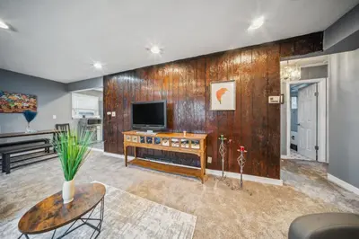 a living room with a tv on a wooden wall at Blue Bayou Cozy in South Cleveland in Cleveland
