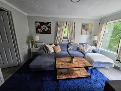 a living room with a blue couch and a table at Great little house in Woodmere Beachwood Orange in Woodmere