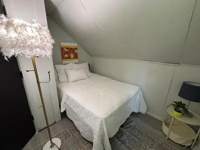 a small room with a bed and a lamp at Great little house in Woodmere Beachwood Orange in Woodmere