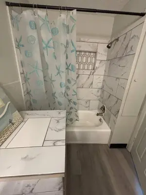 a bathroom with a shower and a tub and a sink at Great little house in Woodmere Beachwood Orange in Woodmere