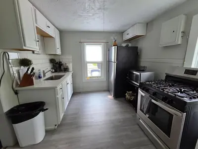 a kitchen with a refrigerator and a stove top oven at Great little house in Woodmere Beachwood Orange in Woodmere