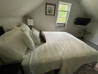 a bedroom with a large bed with white sheets and pillows at Great little house in Woodmere Beachwood Orange in Woodmere