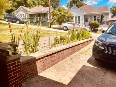 a brick retaining wall in front of a house at Del La Rose in Clarksburg