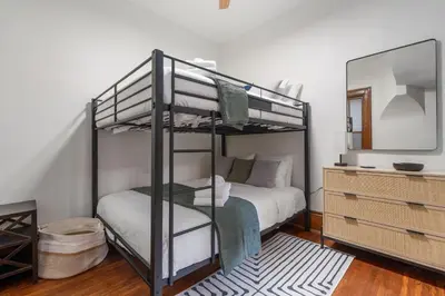 a bedroom with a bunk bed and a mirror at Short North Luxury 4BR Free Parking & Fire Pit in Columbus