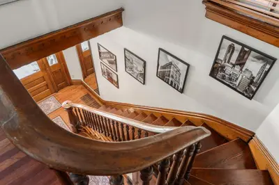 a wooden staircase with pictures on the wall at Short North Luxury 4BR Free Parking & Fire Pit in Columbus