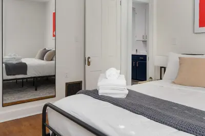 a bedroom with two beds and a mirror at Short North Luxury 4BR Free Parking & Fire Pit in Columbus