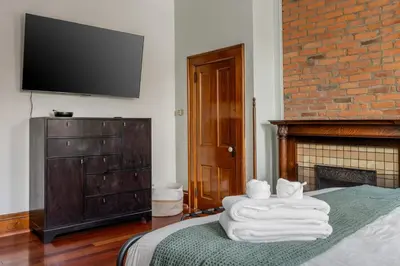 a bedroom with a bed and a tv on the wall at Short North Luxury 4BR Free Parking & Fire Pit in Columbus