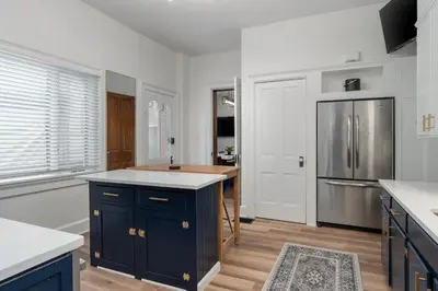 a kitchen with blue cabinets and a stainless steel refrigerator at Short North Luxury 4BR Free Parking & Fire Pit in Columbus