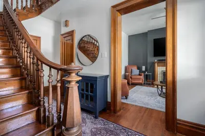 a hallway with a stairway with a mirror at Short North Luxury 4BR Free Parking & Fire Pit in Columbus