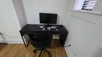 a black computer desk with a monitor and a chair at Quiet cheerful condo in the heart of OTR! in Cincinnati