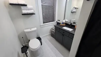 a white bathroom with a toilet and a sink at Quiet cheerful condo in the heart of OTR! in Cincinnati
