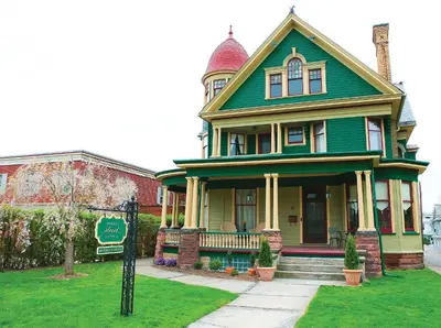a green house with a sign in front of it at Market Street Inn in Wooster