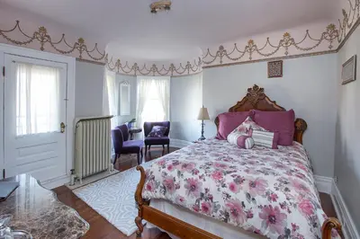 a bedroom with a bed with a pink bedspread at Market Street Inn in Wooster