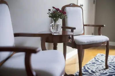 a vase of flowers on a table with two chairs at Market Street Inn in Wooster