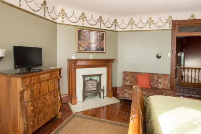 a bedroom with a fireplace and a bed and a television at Market Street Inn in Wooster