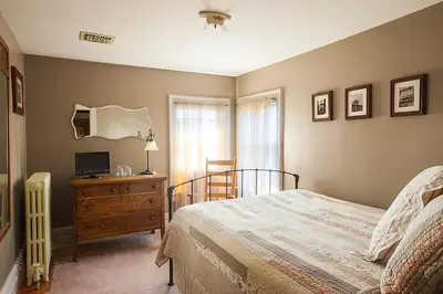 a bedroom with a bed and a dresser with a television at Market Street Inn in Wooster