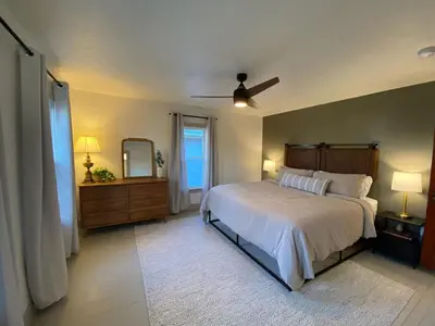 a bedroom with a large bed and a mirror at Totally renovated large family getaway! King bed
