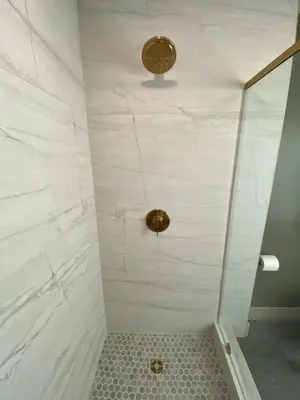 a bathroom with a shower with white marble walls at Totally renovated large family getaway! King bed