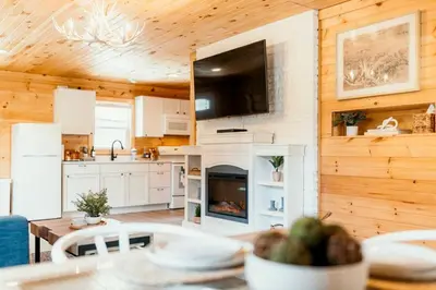 a kitchen and dining room with a table and a fireplace at Creekside Hocking Hills Cabin-Game Shed Hot Tub in South Bloomingville