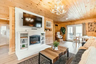a living room with a fireplace and a tv at Creekside Hocking Hills Cabin-Game Shed Hot Tub in South Bloomingville