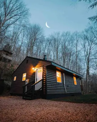 a small cabin with a moon in the sky at Creekside Hocking Hills Cabin-Game Shed Hot Tub in South Bloomingville