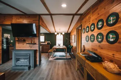a living room with a fireplace and a tv at Emerald Edge Hocking Hills Midcentury Cabin & Hot Tub in South Bloomingville