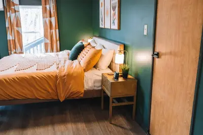 a bedroom with a bed and a side table at Emerald Edge Hocking Hills Midcentury Cabin & Hot Tub in South Bloomingville