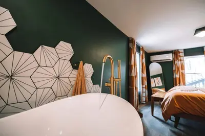 a bedroom with a bed and a green wall at Emerald Edge Hocking Hills Midcentury Cabin & Hot Tub in South Bloomingville