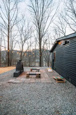 a patio with a picnic table and a building at Emerald Edge Hocking Hills Midcentury Cabin & Hot Tub in South Bloomingville