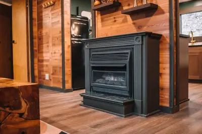a fireplace in a room with a wooden floor at Emerald Edge Hocking Hills Midcentury Cabin & Hot Tub in South Bloomingville