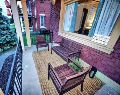 a porch with two chairs and a bench on a house at Nell's Place in Cincinnati