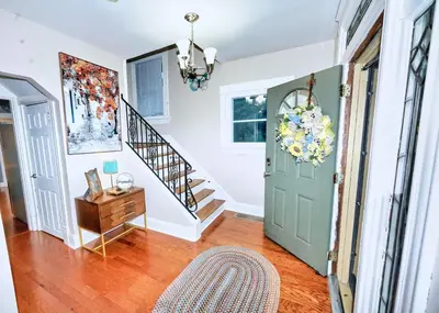 a hallway with a green door and a stairway at Nell's Place in Cincinnati