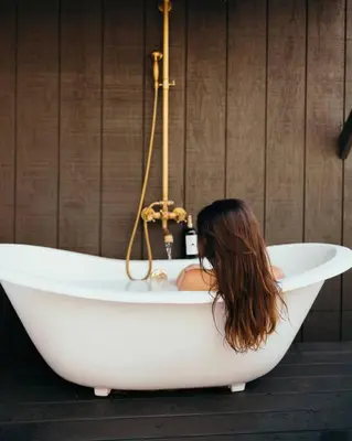 a woman is sitting in a bath tub at Victorian French Cottage - Hot Tub in Hocking Hills in South Bloomingville