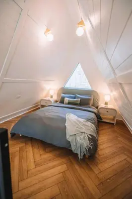a bedroom with a large bed in a attic at Secluded A-Frame Hocking Hills Hot Tub Fire Pit in South Bloomingville
