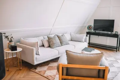 a living room with a white couch and a television at Secluded A-Frame Hocking Hills Hot Tub Fire Pit in South Bloomingville
