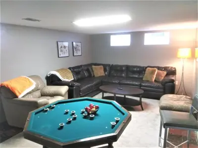a living room with a couch and a pool table at Affordable for 8 guests-King bed-2 Baths-Firepit in Brooklyn