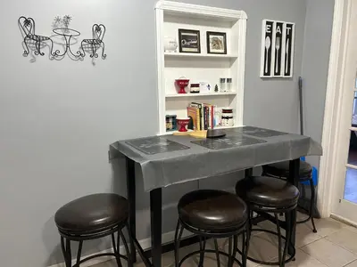 a table with stools in a room with a shelf at Affordable for 8 guests-King bed-2 Baths-Firepit in Brooklyn