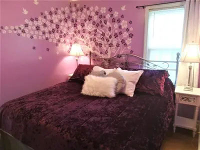 a bedroom with a bed with a purple wall at Affordable for 8 guests-King bed-2 Baths-Firepit in Brooklyn