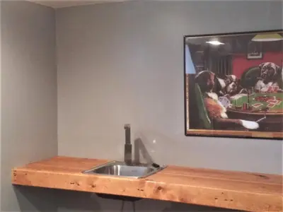 a bathroom with a sink and a picture of dogs at Affordable for 8 guests-King bed-2 Baths-Firepit in Brooklyn