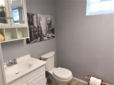 a bathroom with a white toilet and a sink at Affordable for 8 guests-King bed-2 Baths-Firepit in Brooklyn