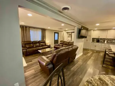 a large living room with leather furniture and a kitchen at [4-BR/Sleeps 12] Family & Friends Home in Indiana in New Haven