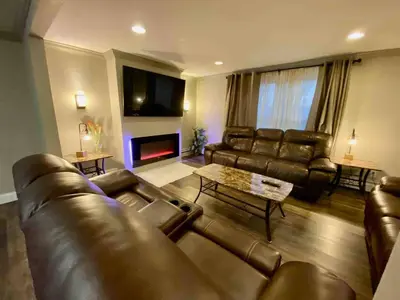 a living room with a leather couch and a fireplace at [4-BR/Sleeps 12] Family & Friends Home in Indiana in New Haven