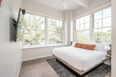 a bedroom with white walls and windows and a bed at The 333 Suites 203 - Stay for 6 in Cincinnati