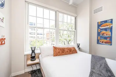 a white bedroom with a bed and a window at The 333 Suites 203 - Stay for 6 in Cincinnati