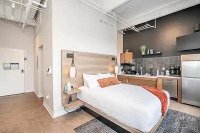 a bedroom with a large bed and a kitchen at The 333 Suites 204 - Stay for 2 in Cincinnati
